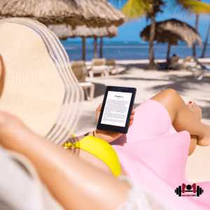 Жена на лятна почивка, която чете електронна книга на плажа от своя Kindle четец